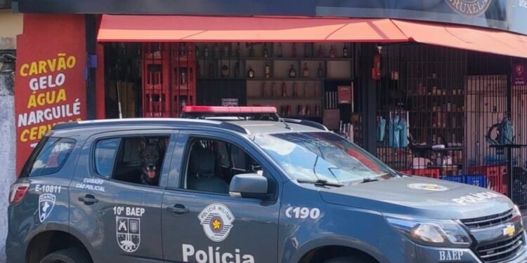 Cão policial do Baep ao lado de drogas, dinheiro e bebidas falsificadas apreendidas em adega no bairro São Jerônimo, em Americana (SP).