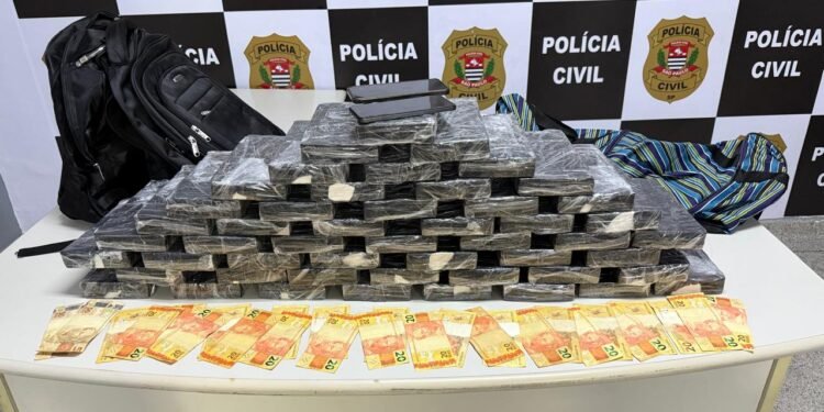 Blocos de 50 kg de cocaína apreendidos pela Polícia Civil dispostos sobre uma mesa em delegacia após prisão de um casal em Ferraz de Vasconcelos, na Grande São Paulo.