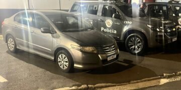 Imagem mostra um veículo Honda City de cor prata apreendido pelo BAEP em frente ao Plantão Policial de Sumaré, ao lado de viaturas da Polícia Militar, durante ocorrência de receptação de veículo roubado.
