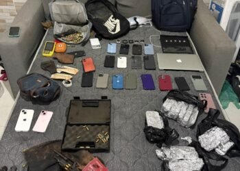 casa cofre com 96 celulares roubados apreendidos pela Polícia Militar em Paraisópolis #PraCegoVer Policiais militares organizam dezenas de celulares e notebooks apreendidos sobre uma mesa em imóvel simples na comunidade