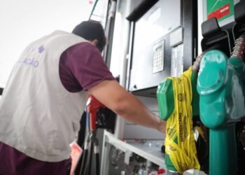 força-tarefa interdita posto irregular e lacra bombas de combustível em operação contra fraude #PraCegoVer fiscais analisam bombas de combustível durante operação de fiscalização em posto