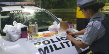 contrabando de anabolizantes em Araçatuba #PraCegoVer: imagem mostra viatura da Polícia Militar Rodoviária parada às margens de rodovia durante a noite, com produtos apreendidos expostos após abordagem.