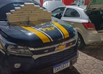 PRF prende três por tráfico de drogas e apreende 31 kg de cocaína na Fernão Dias #PraCegoVer viatura da Polícia Rodoviária Federal com tabletes de cocaína apreendidos sobre o capô ao lado de carro utilizado pelos suspeitos