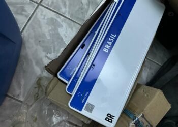 fábrica de placas falsas e tráfico de drogas em SP #PraCegoVer: policiais dentro de imóvel com máquinas de fabricação de placas, peças metálicas e materiais apreendidos durante operação.