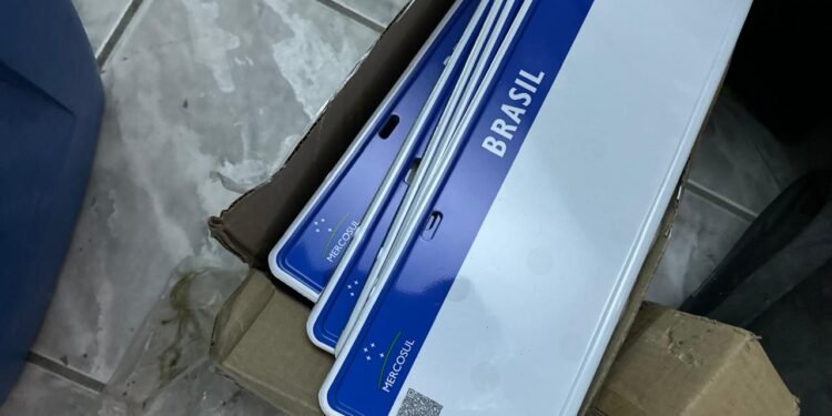 fábrica de placas falsas e tráfico de drogas em SP #PraCegoVer: policiais dentro de imóvel com máquinas de fabricação de placas, peças metálicas e materiais apreendidos durante operação.