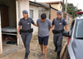 dois procurados capturados em Cosmopolis #PraCegoVer imagem criada por inteligência artificial mostra uma policial militar feminina e um policial militar conduzindo um procurado após ação rápida em bairro residencial, com viatura ao lado e uma casa ao fundo