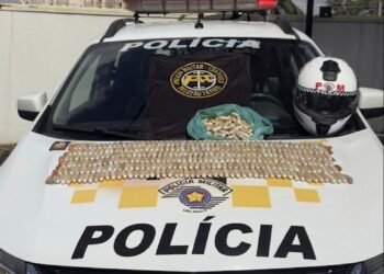 tráfico em ônibus na Marginal Tietê #PraCegoVer imagem mostra uma viatura da Polícia Militar com centenas de cápsulas de cocaína organizadas sobre o capô, além de uma camiseta do Policiamento de Trânsito, um capacete policial e uma sacola com mais cápsulas apreendidas