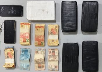 **Text Alt:** Força Tática apreende mais de 5 kg de drogas em Catanduva #PraCegoVer: mesa com tijolos de drogas embalados, dinheiro em espécie, celulares e chave de veículo apreendidos pela Polícia Militar durante ocorrência de tráfico de drogas