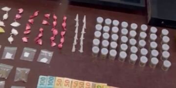 Polícia Militar apreende menor por tráfico em adega #PraCegoVer imagem mostra drogas, dinheiro, máquina de cartão e equipamentos de monitoramento apreendidos durante ocorrência policial