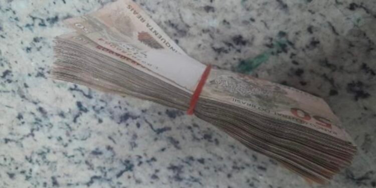 PM apreende 24 toneladas de drogas em rodovia #PraCegoVer imagem mostra cédulas de dinheiro, tablet e aparelhos celulares apreendidos durante ocorrência policial.