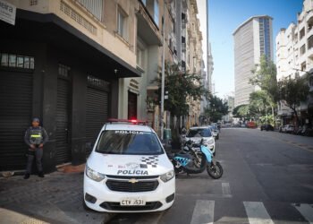 Operação Resgate identificou 4,8 mil frequentadores da Cracolândia com uso de tecnologia em São Paulo #PraCegoVer: viatura da Polícia Militar estacionada em rua do centro de São Paulo durante operação de segurança na antiga região da Cracolândia, com policial realizando patrulhamento em área urbana cercada por prédios.