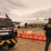 PF prende três suspeitos durante fiscalização migratória no Aeroporto de Guarulhos #PraCegoVer: imagem mostra uma viatura da Polícia Federal estacionada na pista do Aeroporto Internacional de Guarulhos enquanto um agente federal observa uma aeronave comercial ao fundo durante operação de fiscalização.
