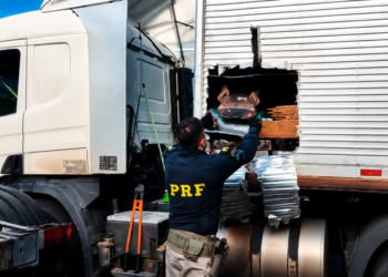 PRF apreende mais de 1 tonelada de maconha e prende homens do interior de SP #PraCegoVer: policiais rodoviários federais fiscalizam caminhão onde foram encontrados fardos de maconha escondidos em carga de ração.