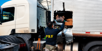 PRF apreende mais de 1 tonelada de maconha e prende homens do interior de SP #PraCegoVer: policiais rodoviários federais fiscalizam caminhão onde foram encontrados fardos de maconha escondidos em carga de ração.