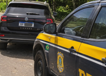PRF apreende veículo com compartimento secreto #PraCegoVer carro abordado durante fiscalização policial na rodovia, onde foram encontrados dinheiro, dólares e cocaína em um compartimento oculto.