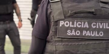 Polícia Civil prende suspeitos de roubo de canetas emagrecedoras em farmácias da Grande São Paulo #PraCegoVer: policial civil com colete da corporação durante operação contra criminosos investigados por roubos de medicamentos em farmácias.