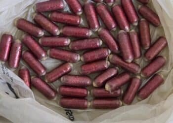 PM apreende cápsulas de cocaína na Marginal Tietê #PraCegoVer: imagem mostra várias cápsulas avermelhadas apreendidas dentro de uma sacola plástica branca sobre uma superfície clara.
