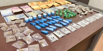tráfico de drogas no Vida Nova #PraCegoVer: imagem mostra uma mesa com porções de drogas embaladas, dinheiro em notas e moedas, além de embalagens separadas para apresentação da ocorrência policial.