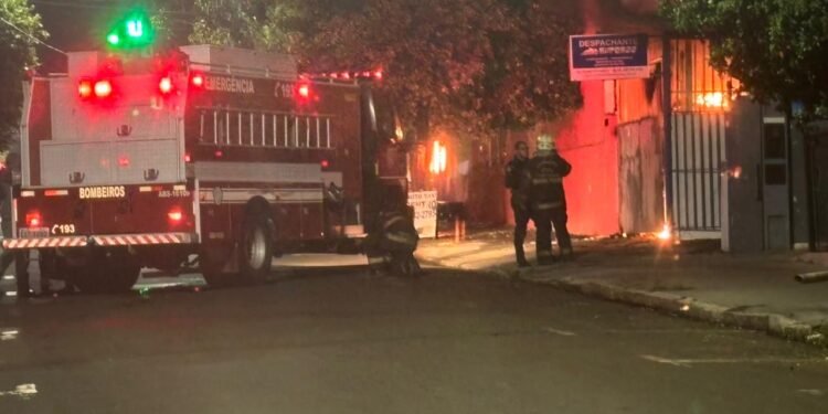 incêndio destrói loja Shopping da Variedade em Cosmópolis #PraCegoVer: Caminhão do Corpo de Bombeiros combate incêndio durante a noite em estabelecimento comercial na região central de Cosmópolis. As chamas atingem o imóvel ao lado enquanto equipes trabalham no isolamento da área.