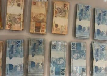 GAECO deflagra operação Rei do Pix mira desvio na Câmara de Catanduva #PraCegoVer imagem mostra maços de dinheiro de 100, 50 e 20 reais encima de uma mesa, dinheiro apreendido na operação.