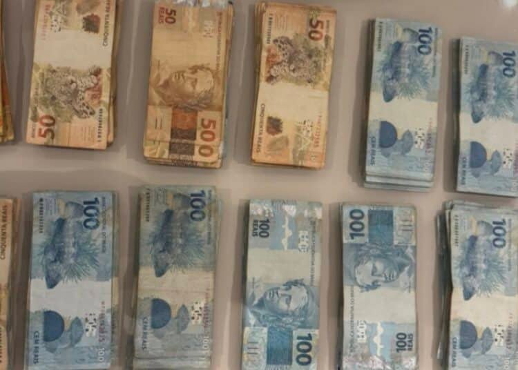GAECO deflagra operação Rei do Pix mira desvio na Câmara de Catanduva #PraCegoVer imagem mostra maços de dinheiro de 100, 50 e 20 reais encima de uma mesa, dinheiro apreendido na operação.