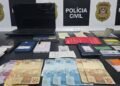 operação Chargeback contra fraude bancária #PraCegoVer aparelhos celulares, documentos, anotações e dinheiro apreendidos durante investigação da Polícia Civil sobre fraudes bancárias e documentais.