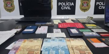 operação Chargeback contra fraude bancária #PraCegoVer aparelhos celulares, documentos, anotações e dinheiro apreendidos durante investigação da Polícia Civil sobre fraudes bancárias e documentais.