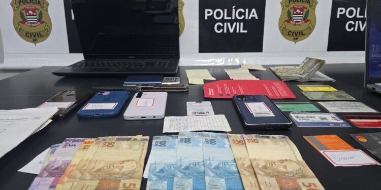 operação Chargeback contra fraude bancária #PraCegoVer aparelhos celulares, documentos, anotações e dinheiro apreendidos durante investigação da Polícia Civil sobre fraudes bancárias e documentais.
