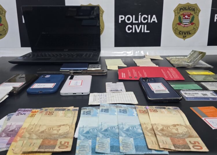 operação Chargeback contra fraude bancária #PraCegoVer aparelhos celulares, documentos, anotações e dinheiro apreendidos durante investigação da Polícia Civil sobre fraudes bancárias e documentais.