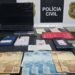 operação Chargeback contra fraude bancária #PraCegoVer aparelhos celulares, documentos, anotações e dinheiro apreendidos durante investigação da Polícia Civil sobre fraudes bancárias e documentais.