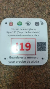 trilhas mapeadas ajudam bombeiros em resgates na Serra do Mar. #PraCegoVer placas de sinalização, numeração e QR Codes em trilhas