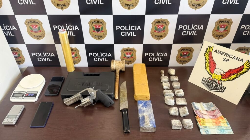 DISE prende traficante na operação Magrelo #PraCegoVer imagem mostra drogas apreendidas, revólver calibre .38, balanças de precisão, dinheiro e materiais usados para fracionamento sobre uma mesa após ação da Polícia Civil